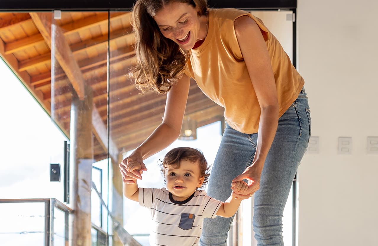 mamá ayudando a caminar a nene bebé