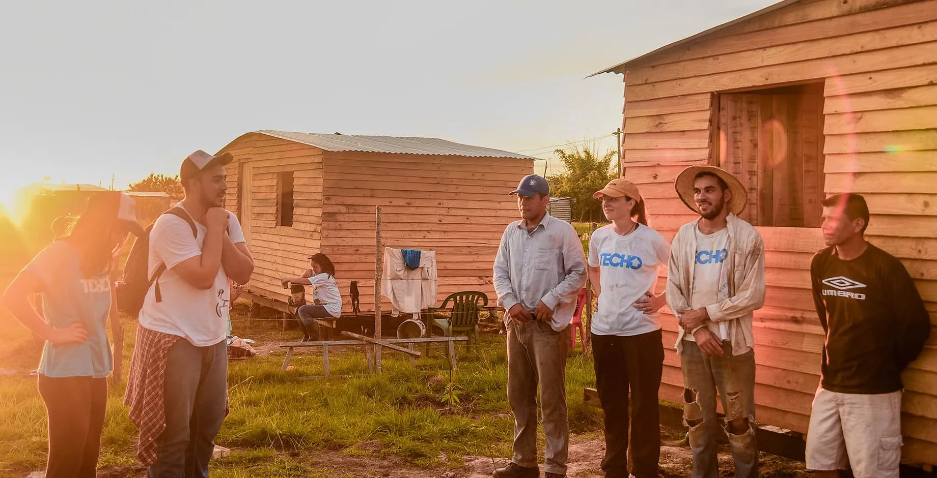 grupo de personas posando delante de una casa un techo para mi país